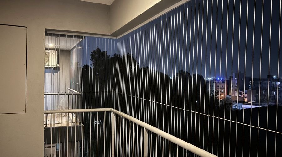 Apartment balcony with transparent invisible grills offering unobstructed city view in Chennai